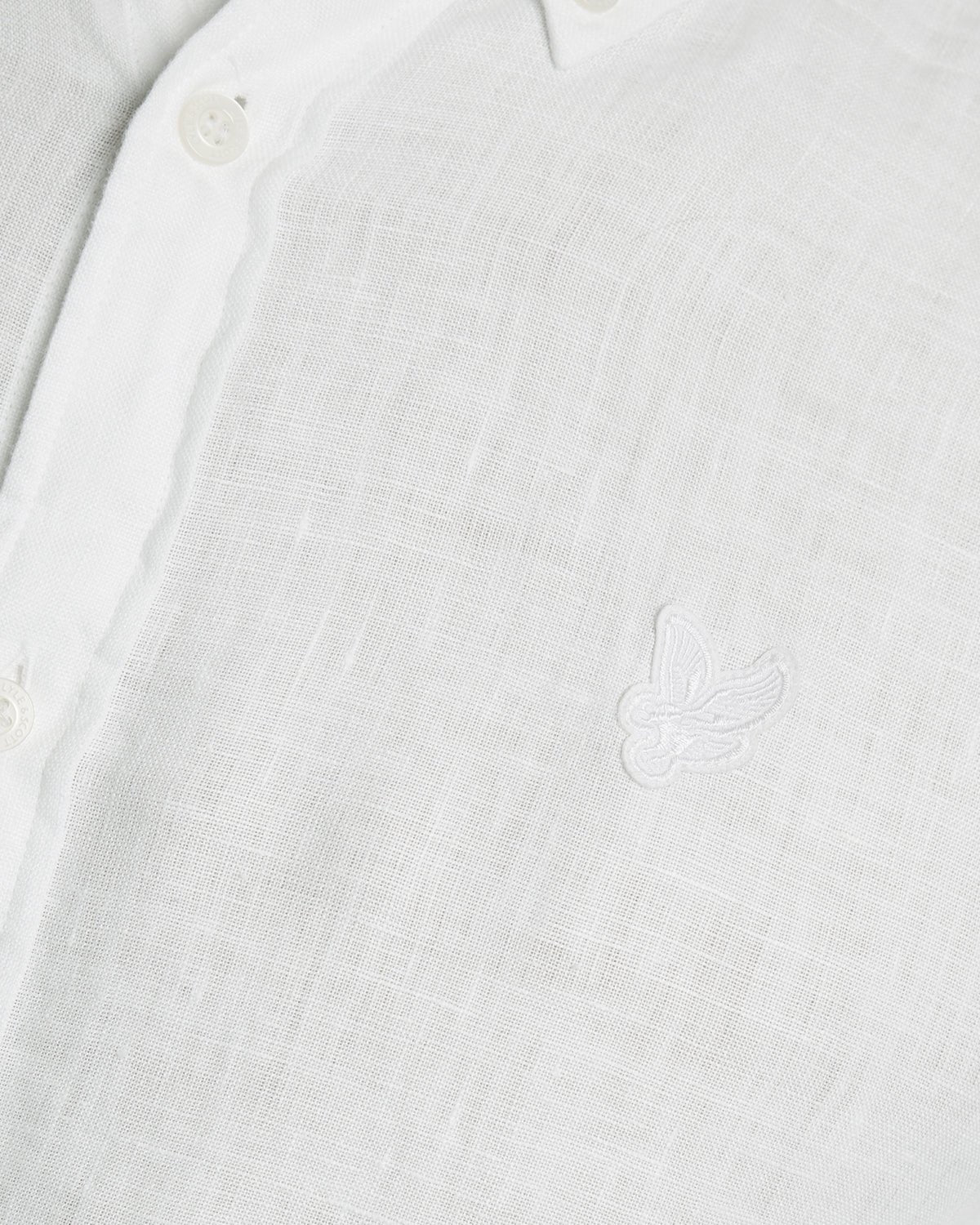 Un homme porte une chemise en lin boutonnée, de couleur blanche
