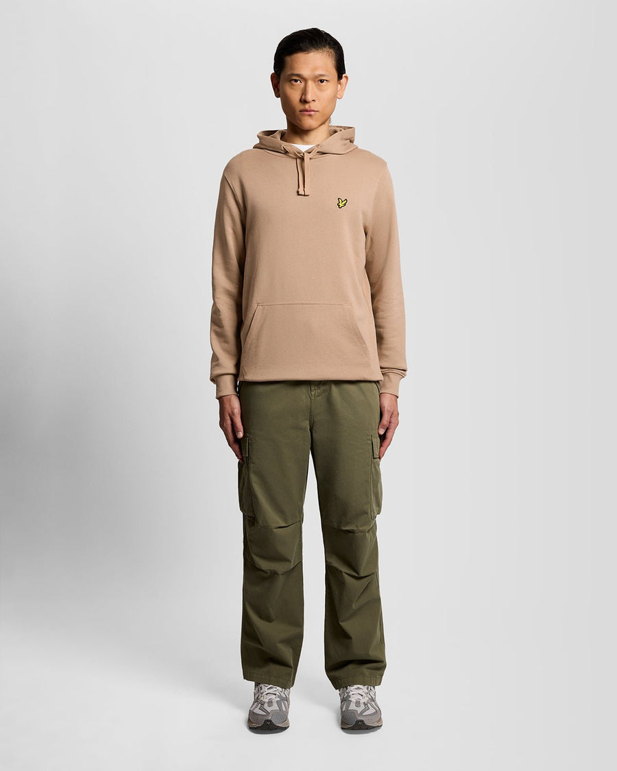 Un homme porte un sweat à capuche en coton Loopback, couleur Barley