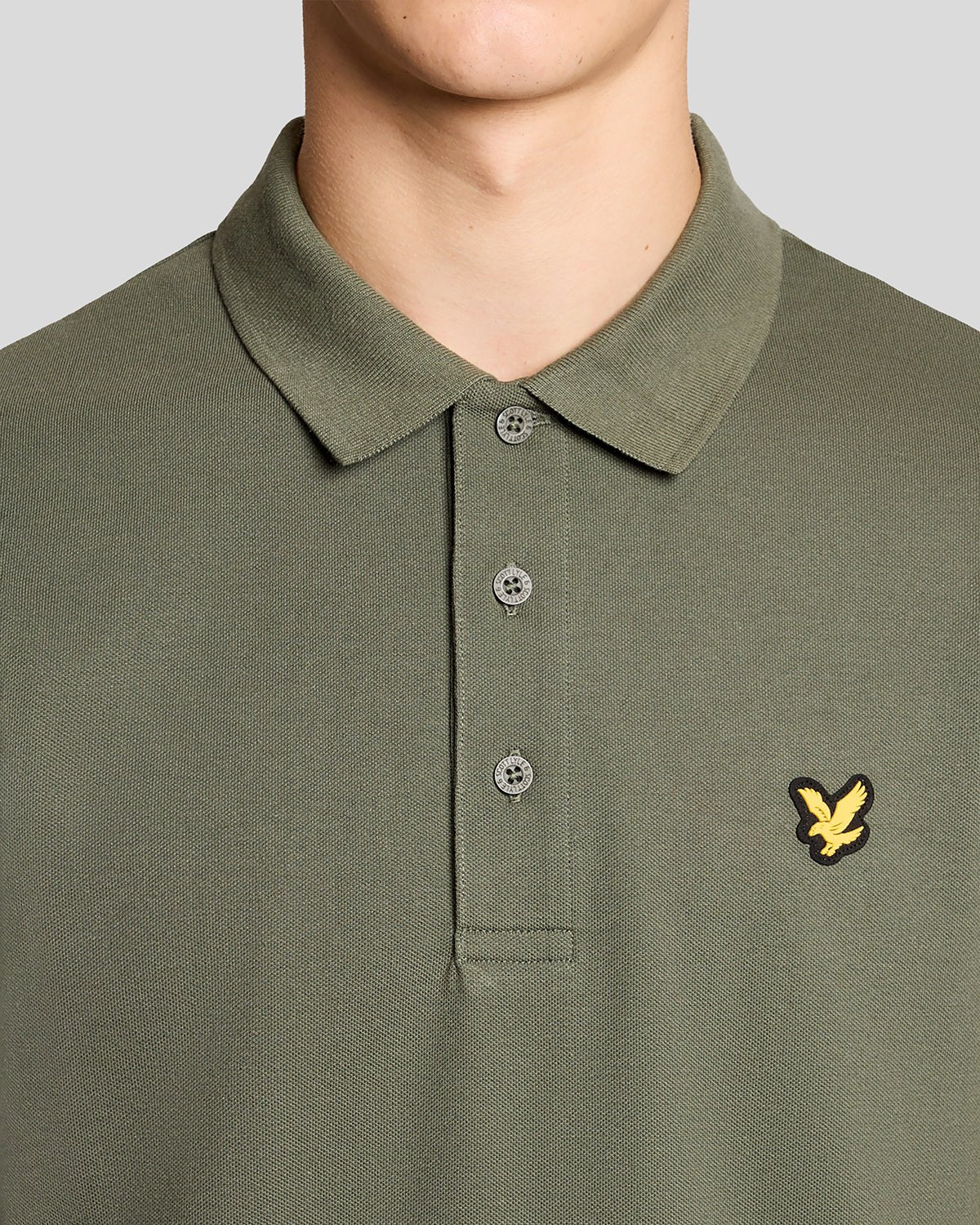 Un homme porte un polo de sport vert cactus