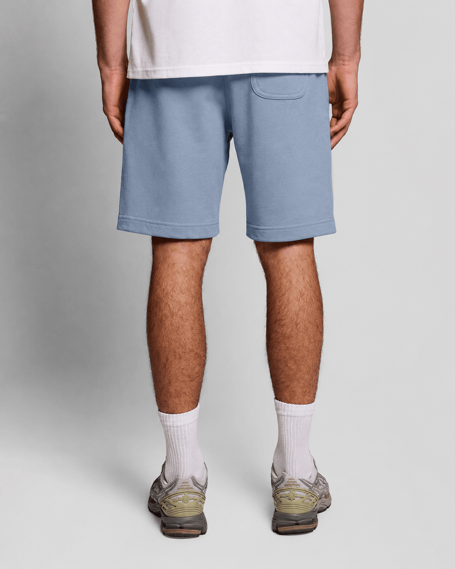 Un homme porte un short de sport en coton bleu opale