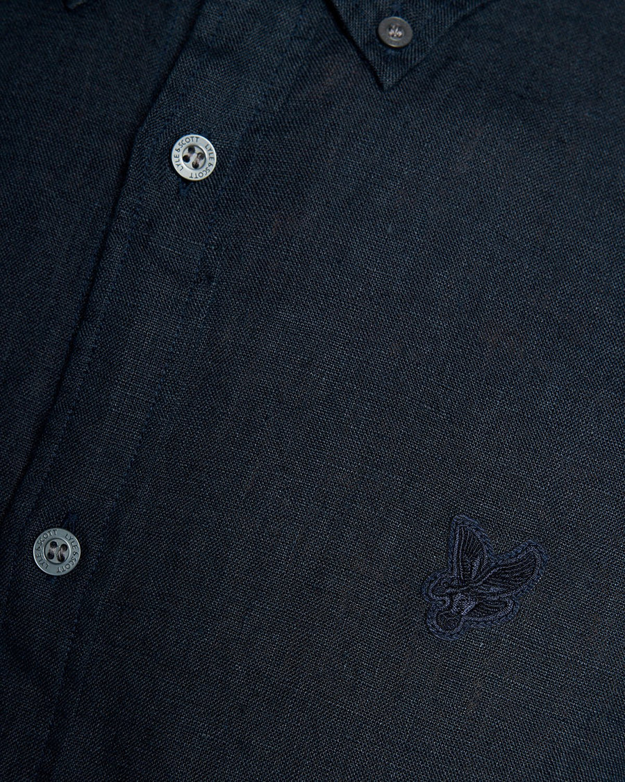 Un homme porte une chemise boutonnée en lin couleur carbone