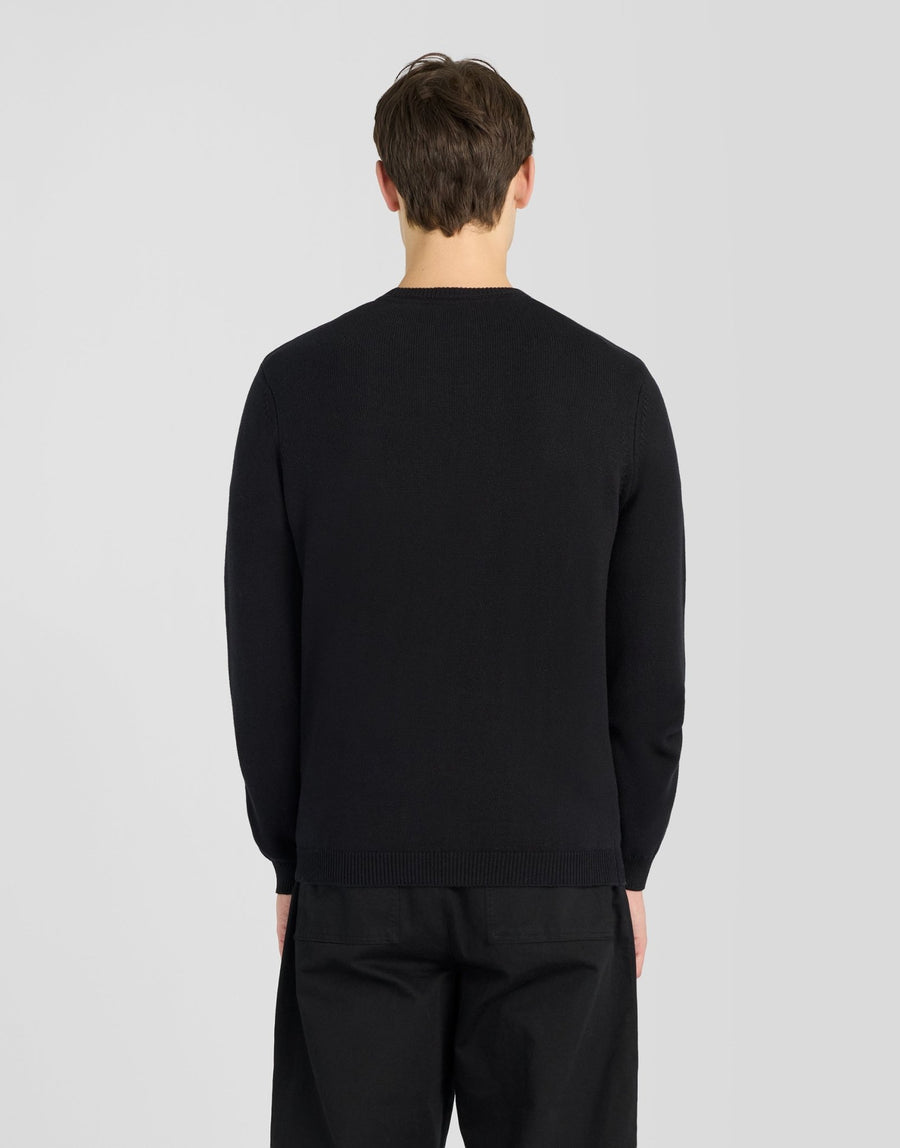 Man wears Cotton Merino Crew Neck Jumper in Jet Black