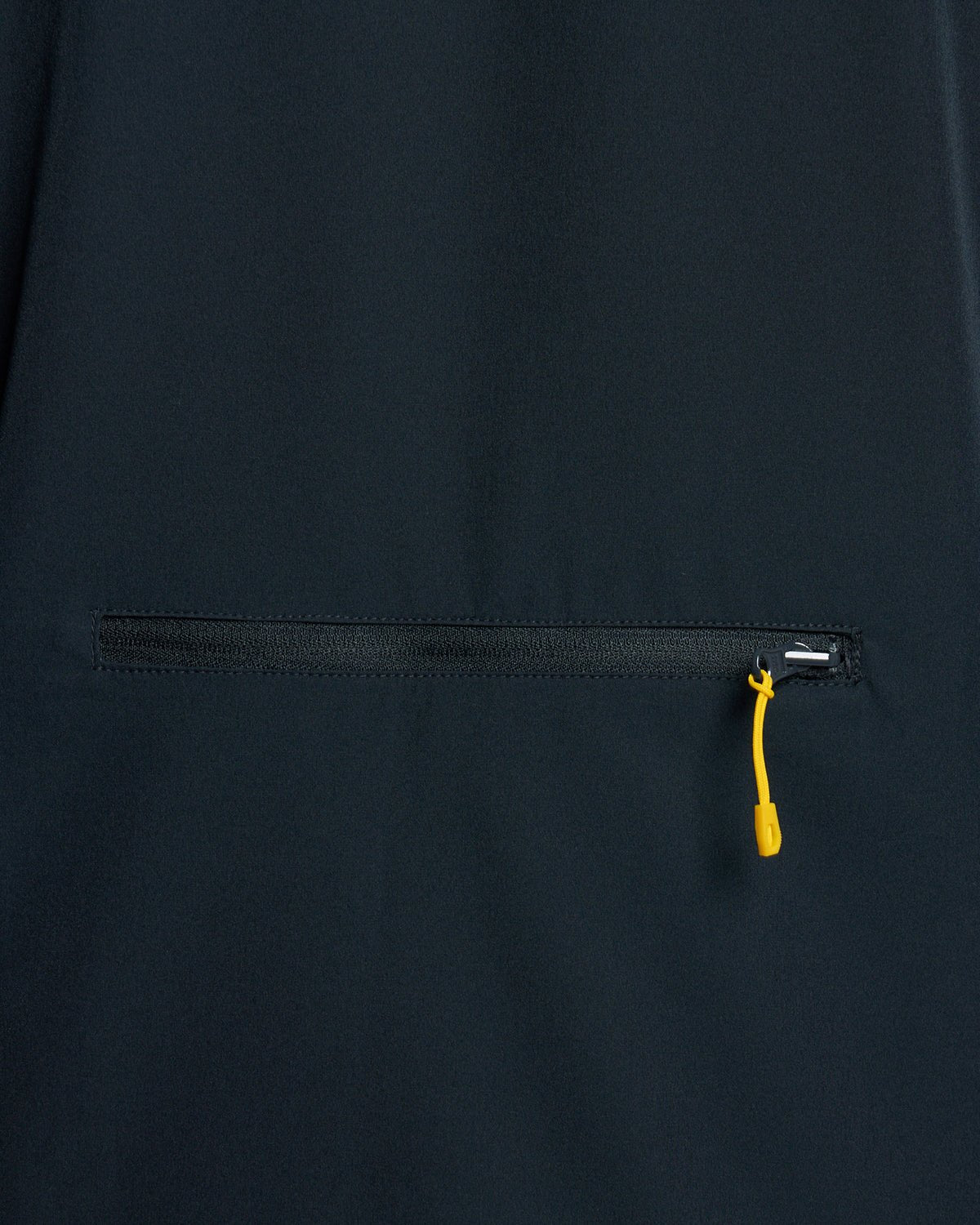 Un homme porte une veste légère et compacte de couleur bleu marine foncé
