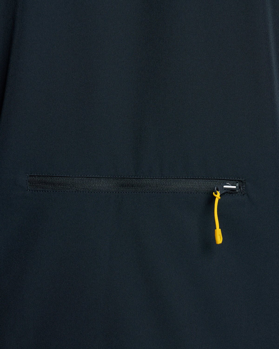 Un homme porte une veste légère et compacte de couleur bleu marine foncé