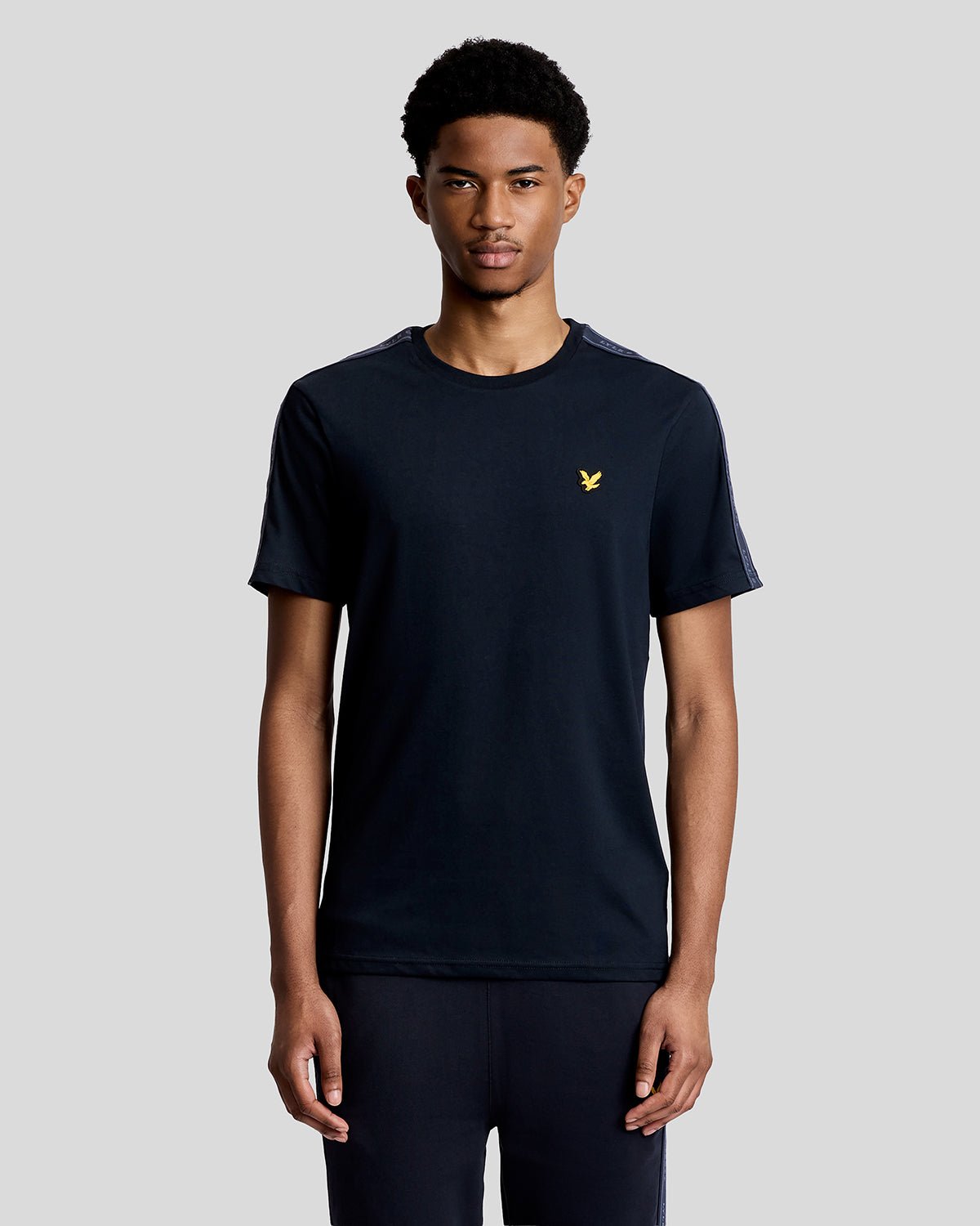 Hombre lleva camiseta deportiva con cinta jacquard en azul marino oscuro.