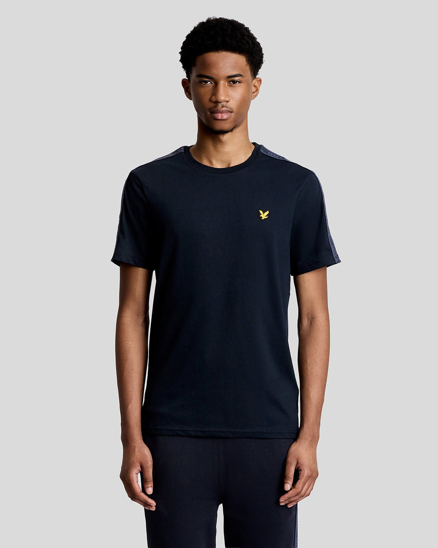 Hombre lleva camiseta deportiva con cinta jacquard en azul marino oscuro.