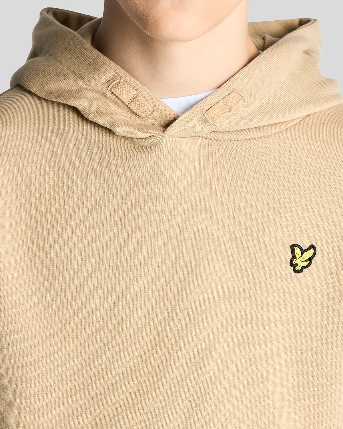 Un homme porte un sweat à capuche en coton Loopback couleur sable foncé
