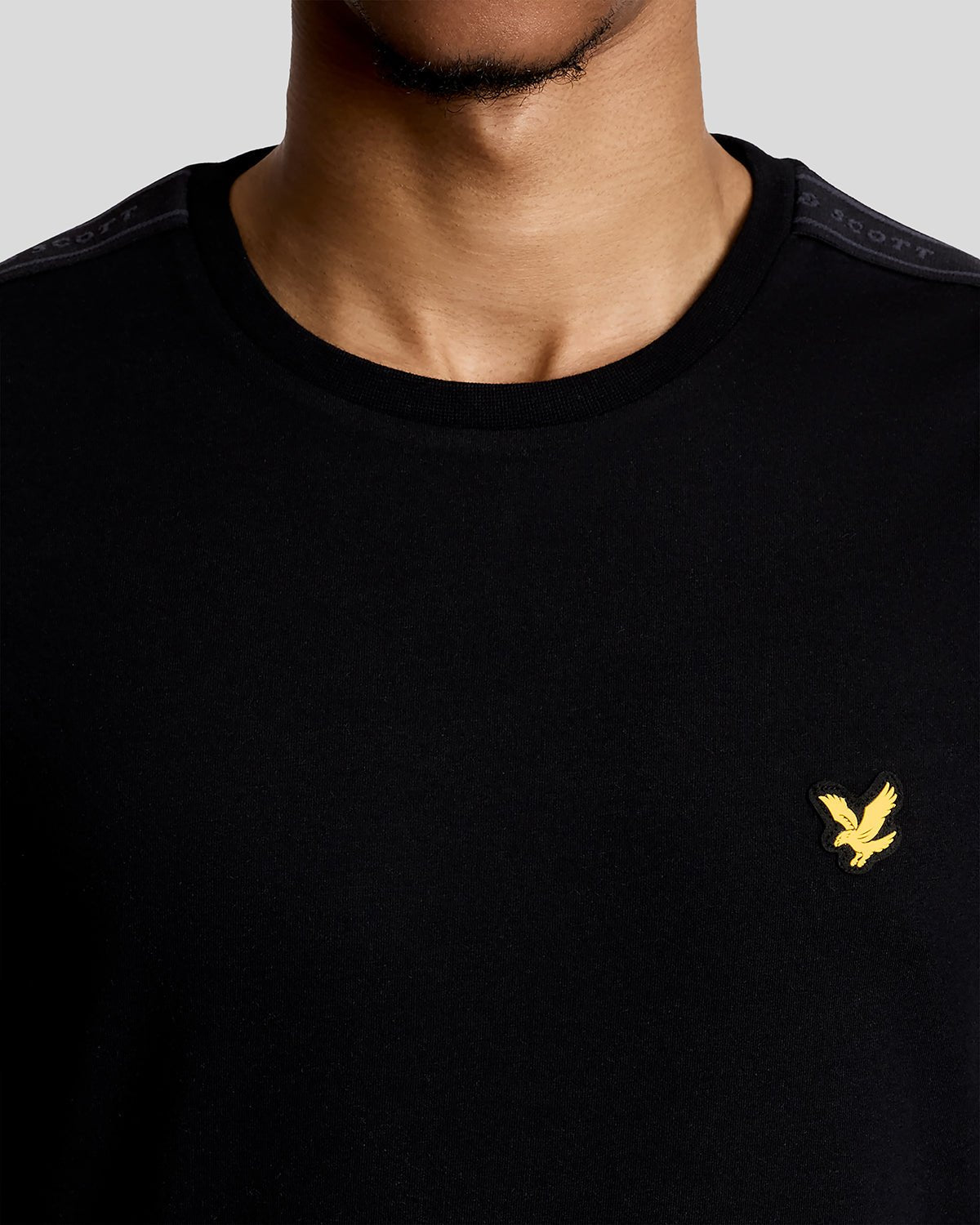 Hombre lleva camiseta deportiva con cinta jacquard en color negro azabache.