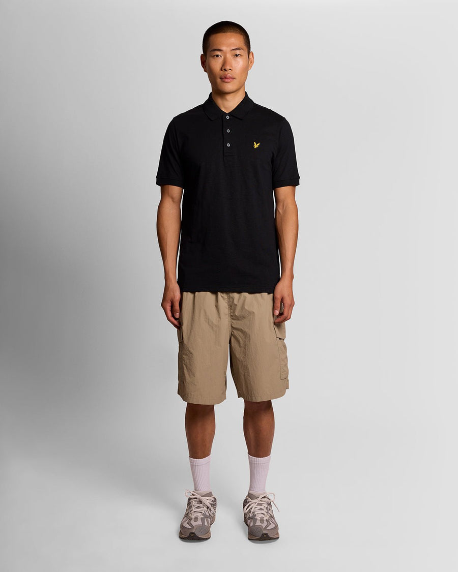 Homme portant un polo en coton fin flammé, couleur noir de jais