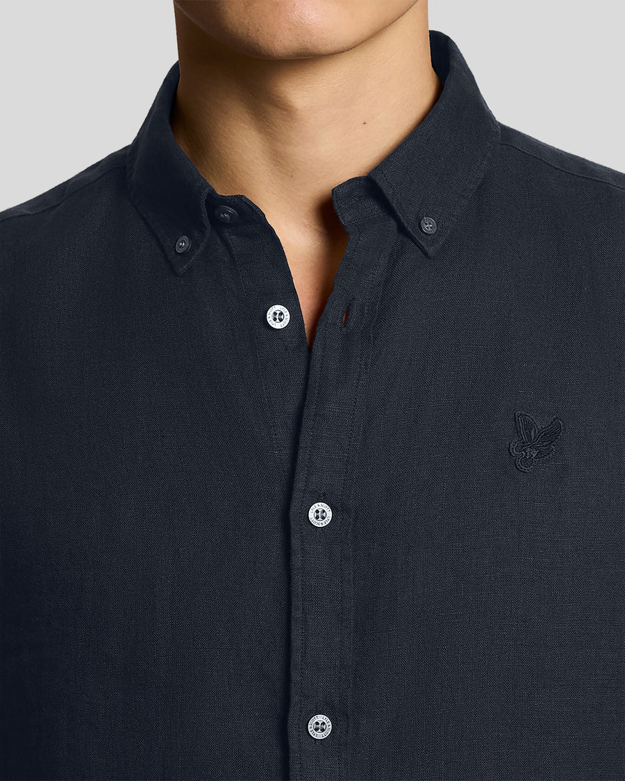 Un homme porte une chemise en lin à manches courtes couleur carbone