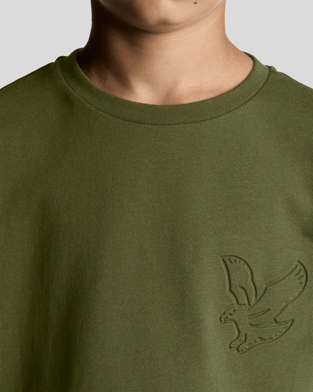 Un garçon porte un t-shirt « Embossed Eagle » dans les profondeurs