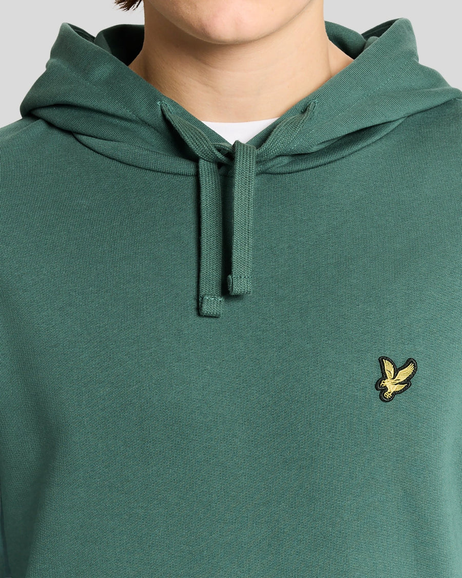 L'uomo indossa una felpa con cappuccio Loopback in cotone color Everglade