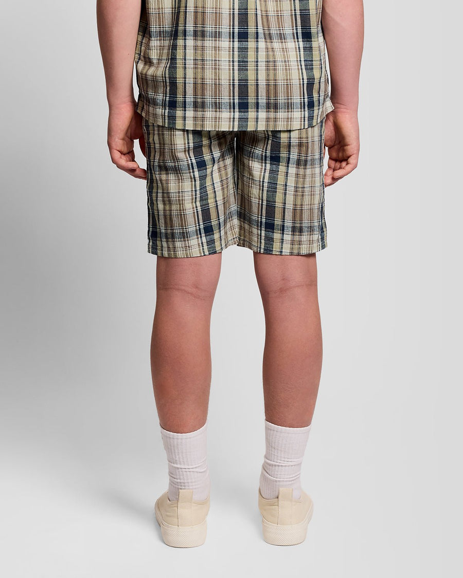 Uomo con pantaloncini a quadri in misto lino, colore verde erba