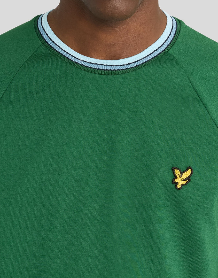 Man wears Tipped Track T-Shirt in Clover Green