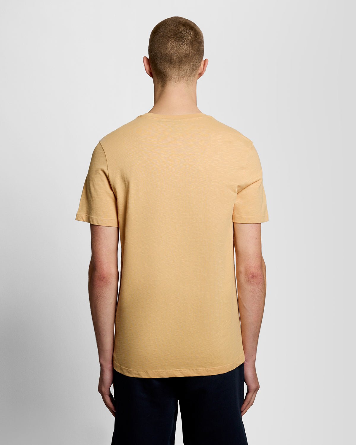 Un homme porte un t-shirt en coton fin texturé, motif nid d'abeille