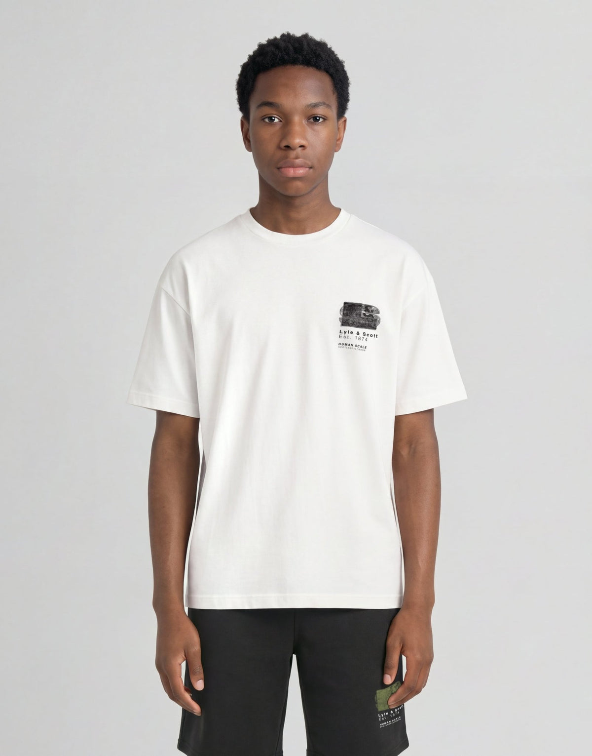 Pojke bär en vit T-shirt med halvtonat monogramtryck