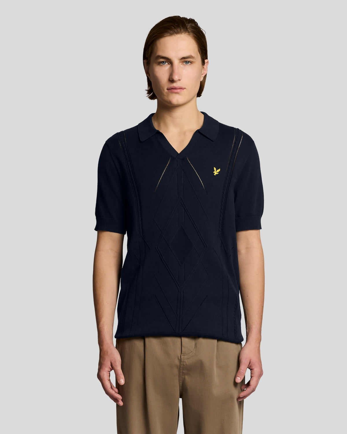 Homme portant un polo en maille à motif argyle et col ouvert, bleu marine foncé
