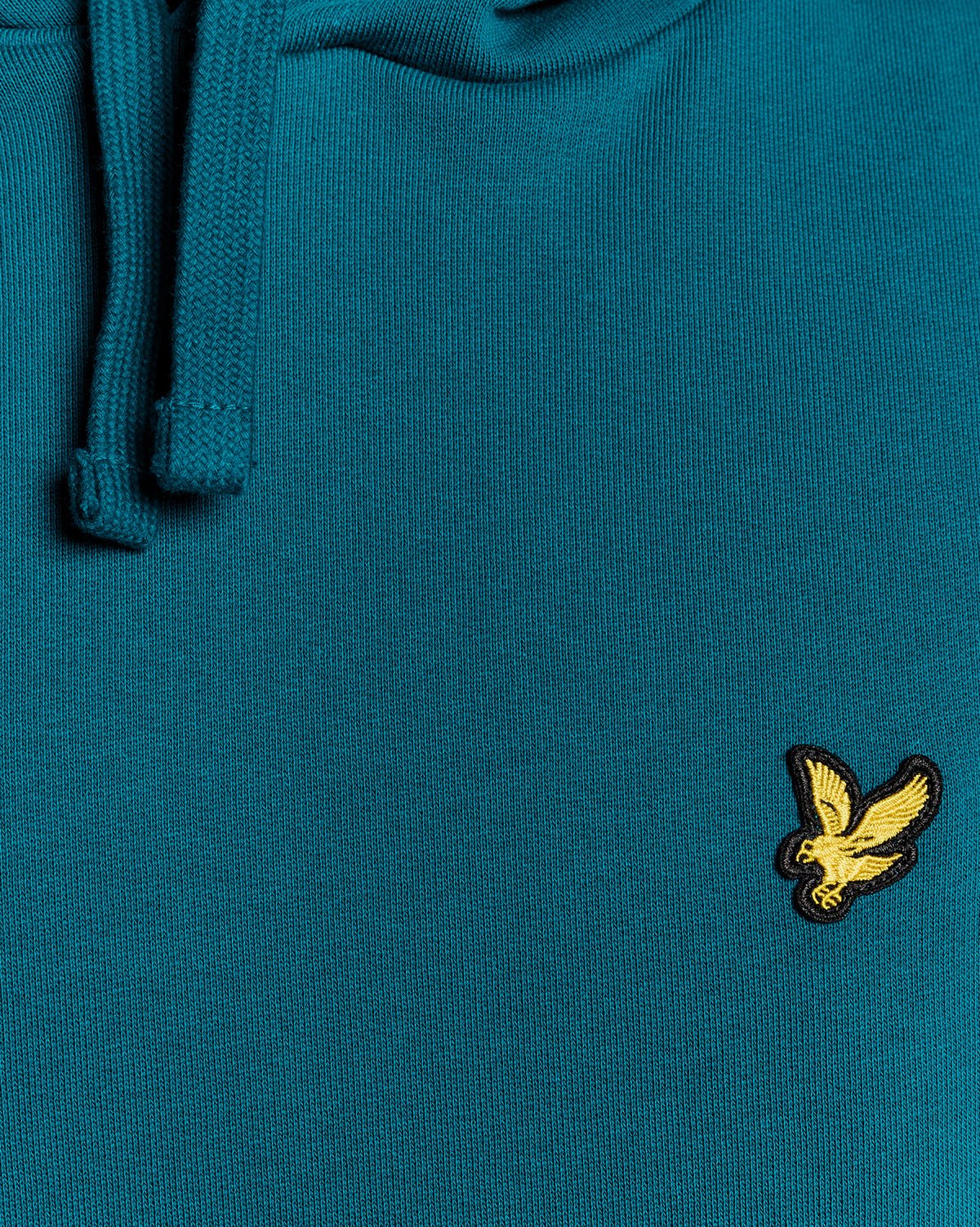 Un homme porte un sweat à capuche en coton Loopback, couleur Lagoon