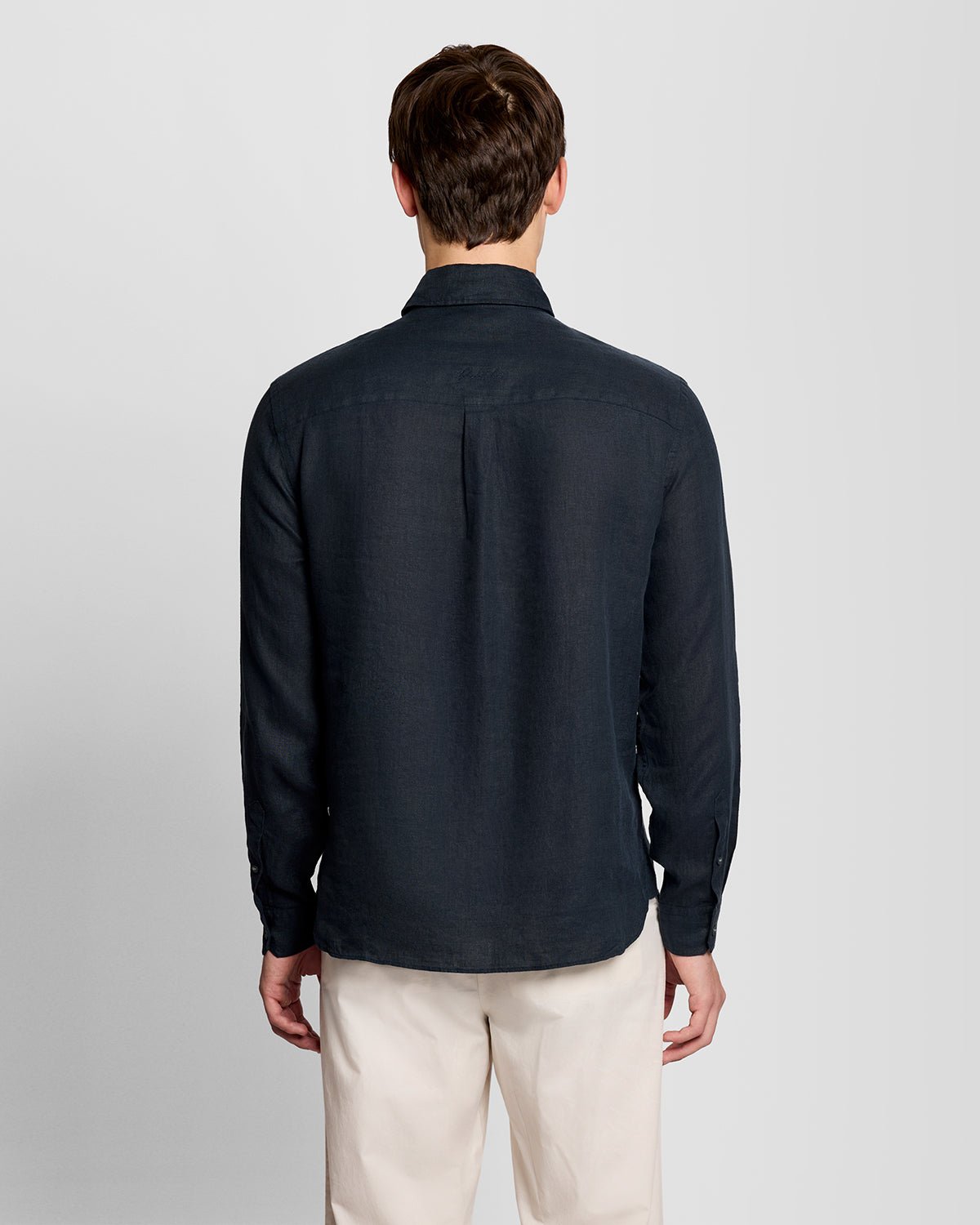 Un homme porte une chemise boutonnée en lin couleur carbone