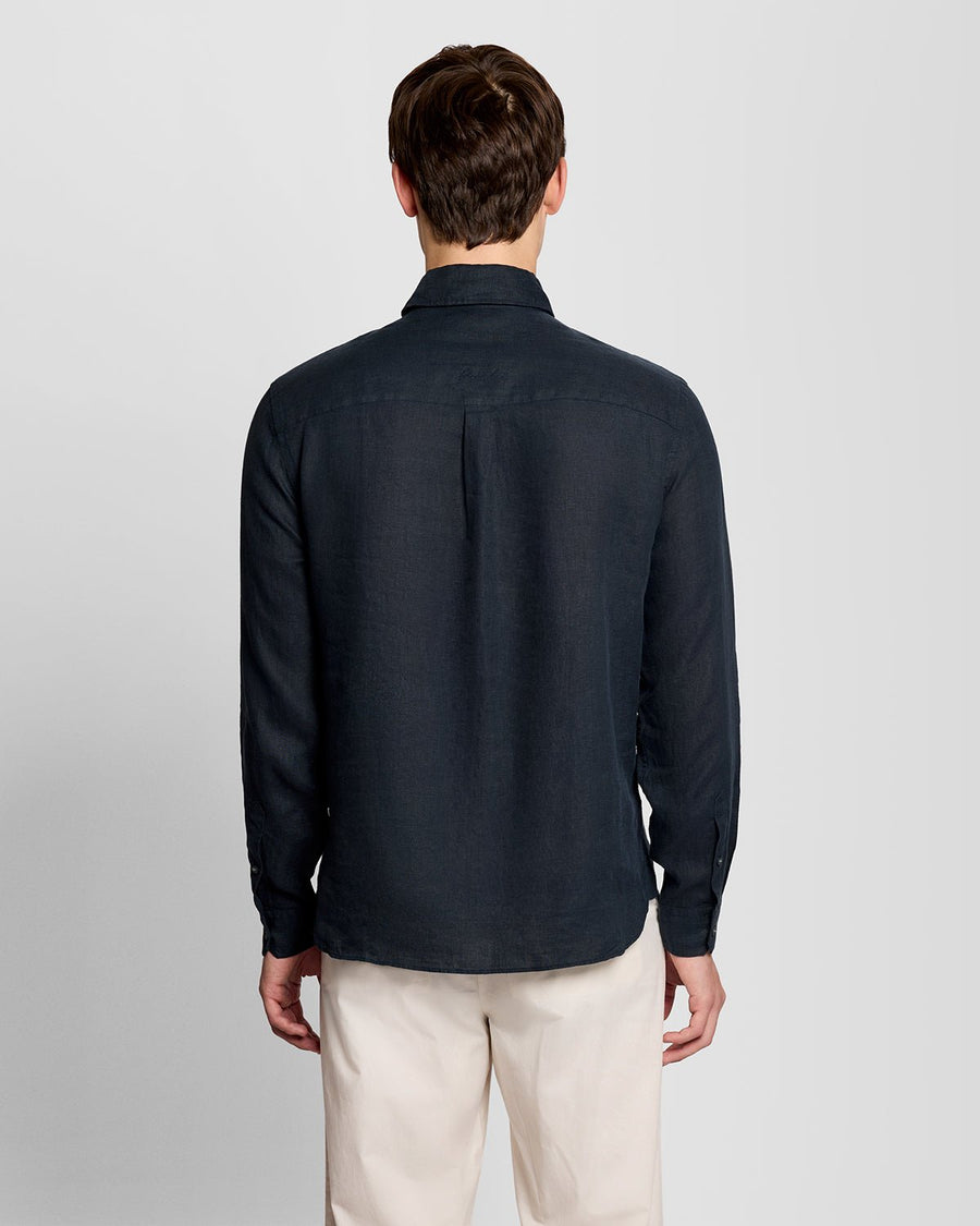 Un homme porte une chemise boutonnée en lin couleur carbone
