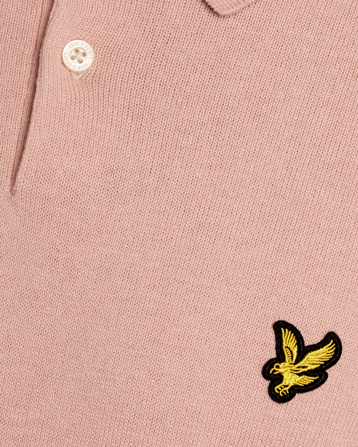 Un homme porte un polo en coton tricoté couleur pamplemousse rose