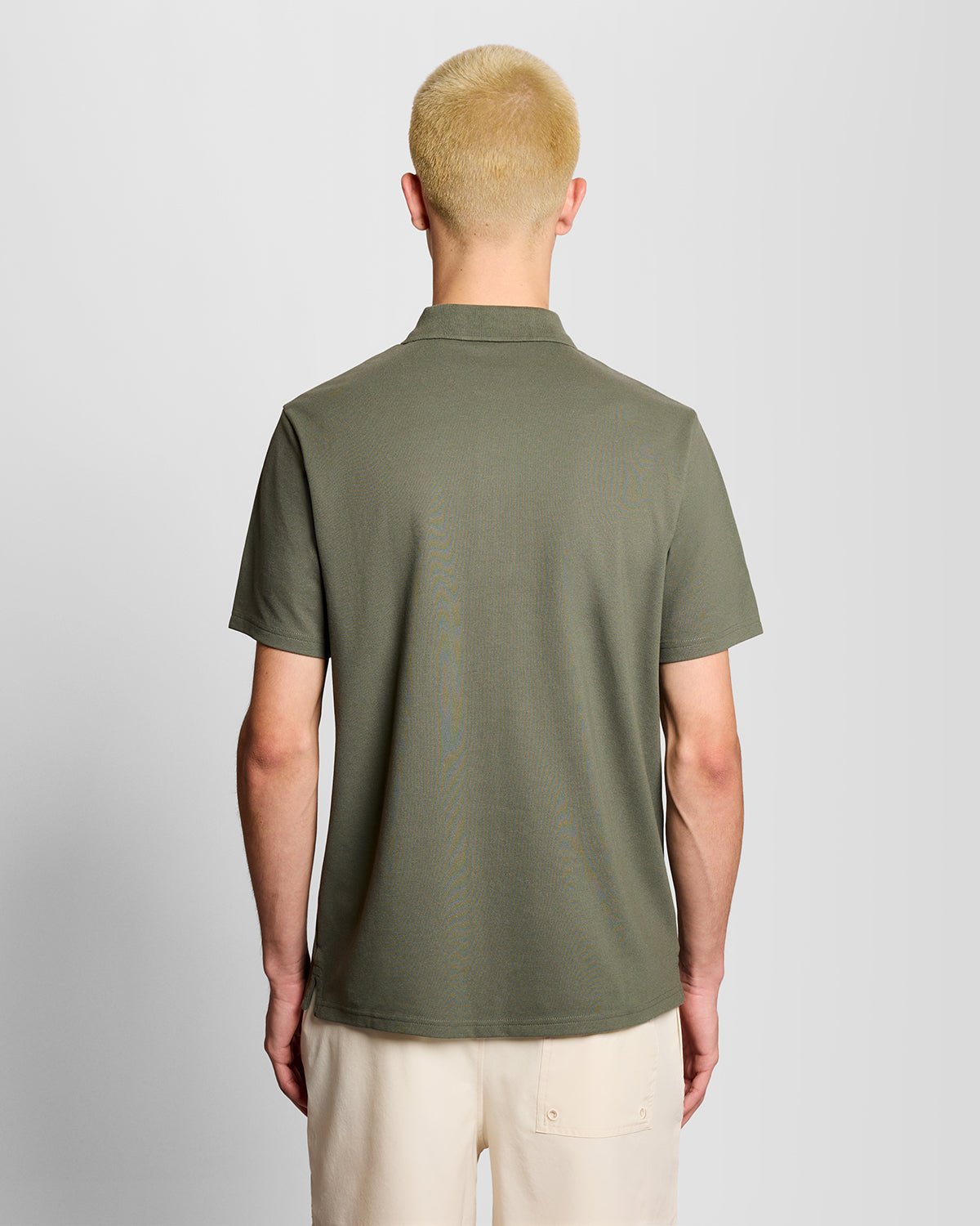 Un homme porte un polo de sport vert cactus