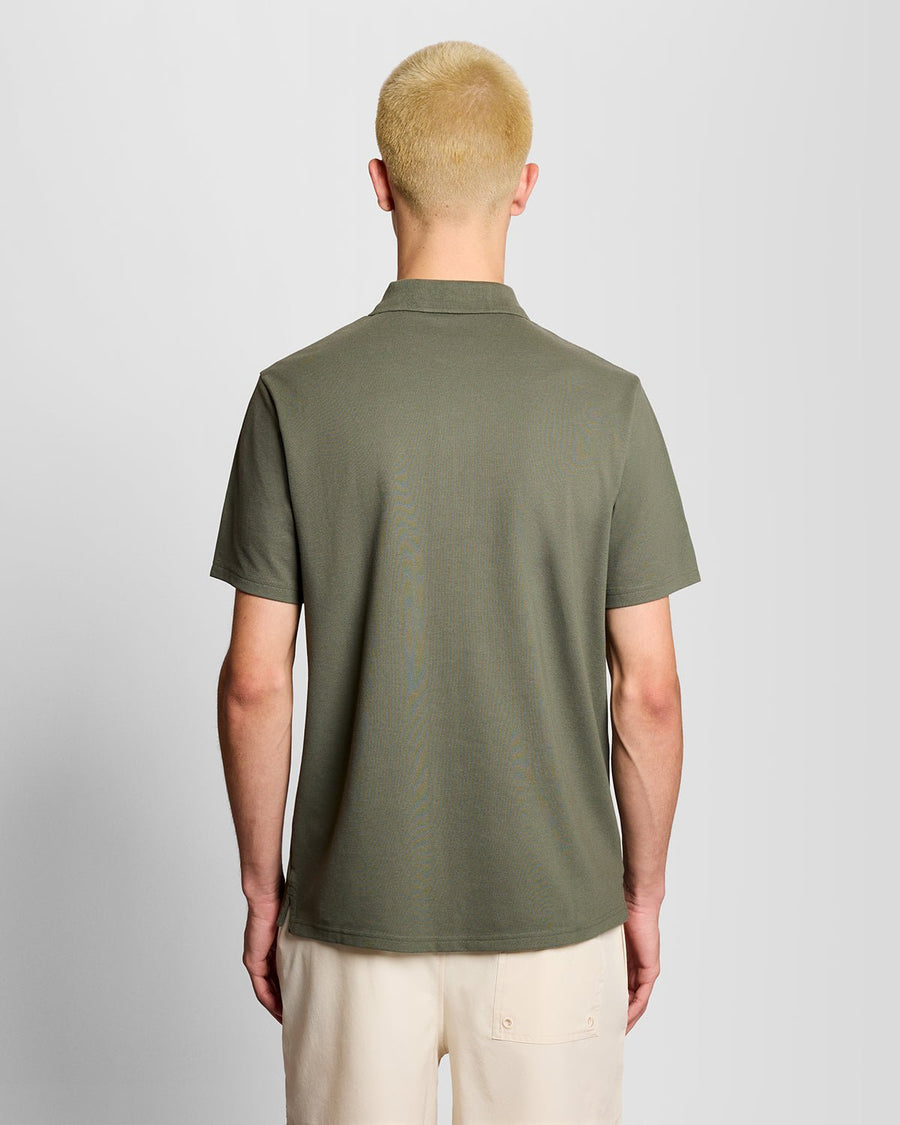 Un homme porte un polo de sport vert cactus