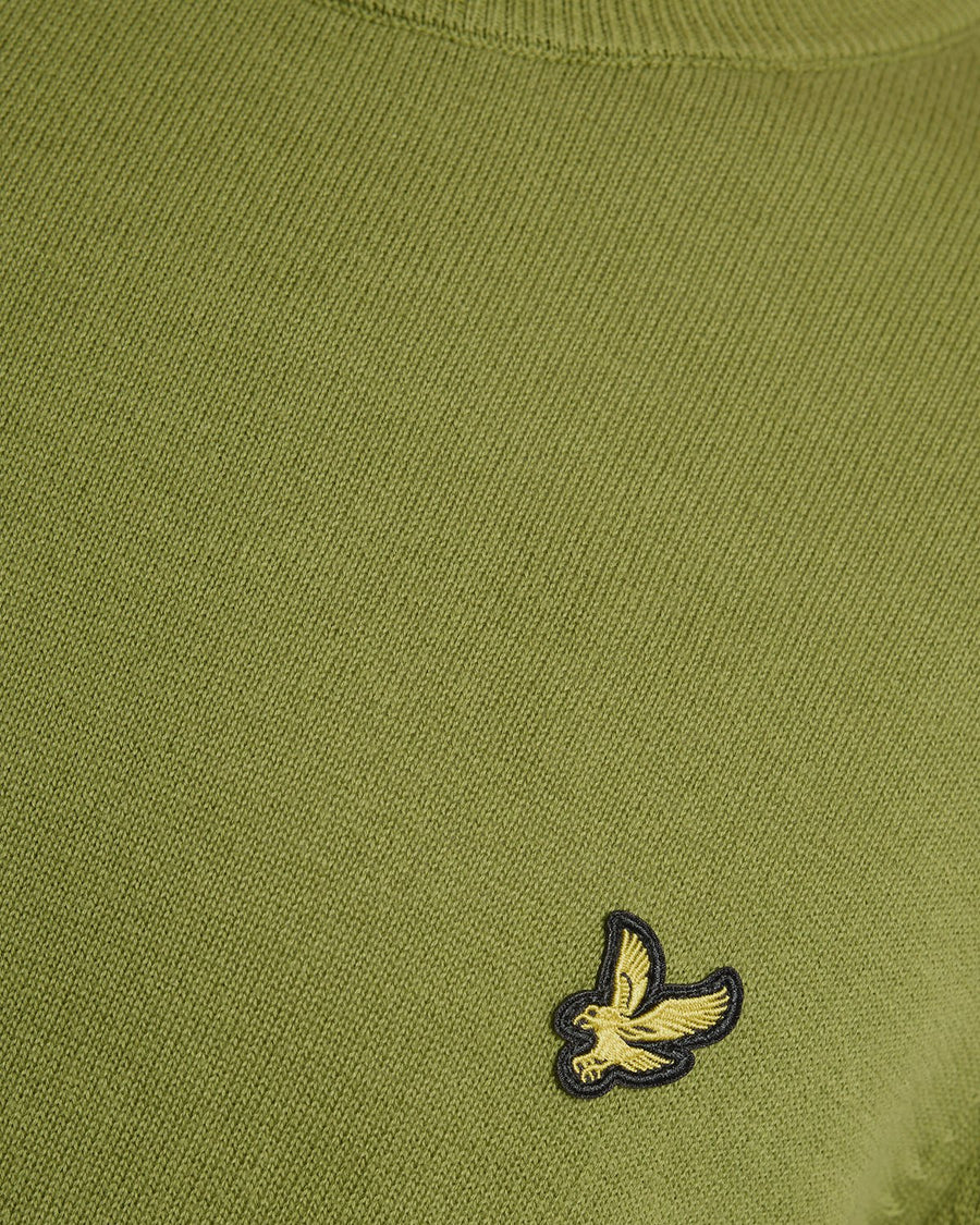 Homme portant un pull à col rond en coton vert buisson