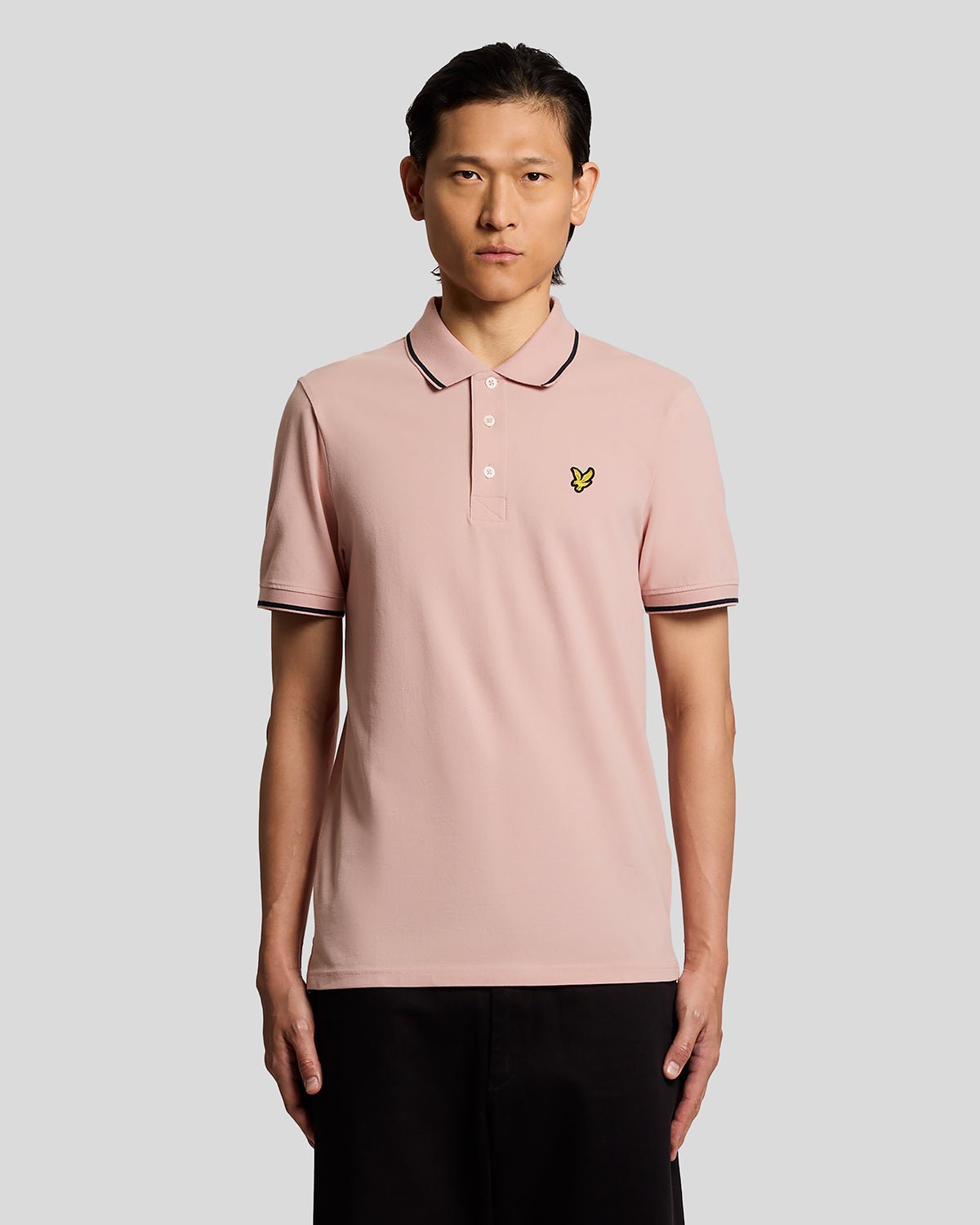 Homme portant un polo à rayures rose pamplemousse et bleu marine foncé