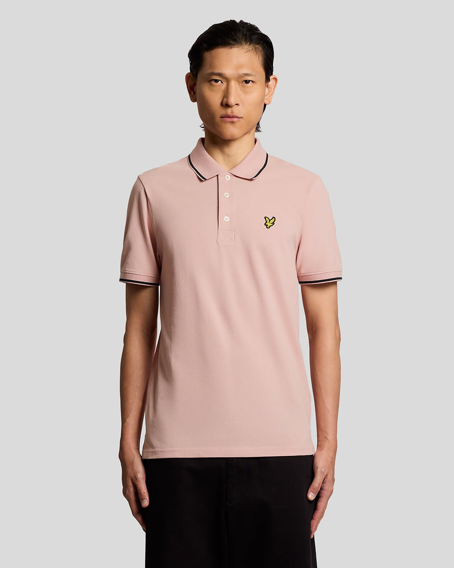 Homme portant un polo à rayures rose pamplemousse et bleu marine foncé