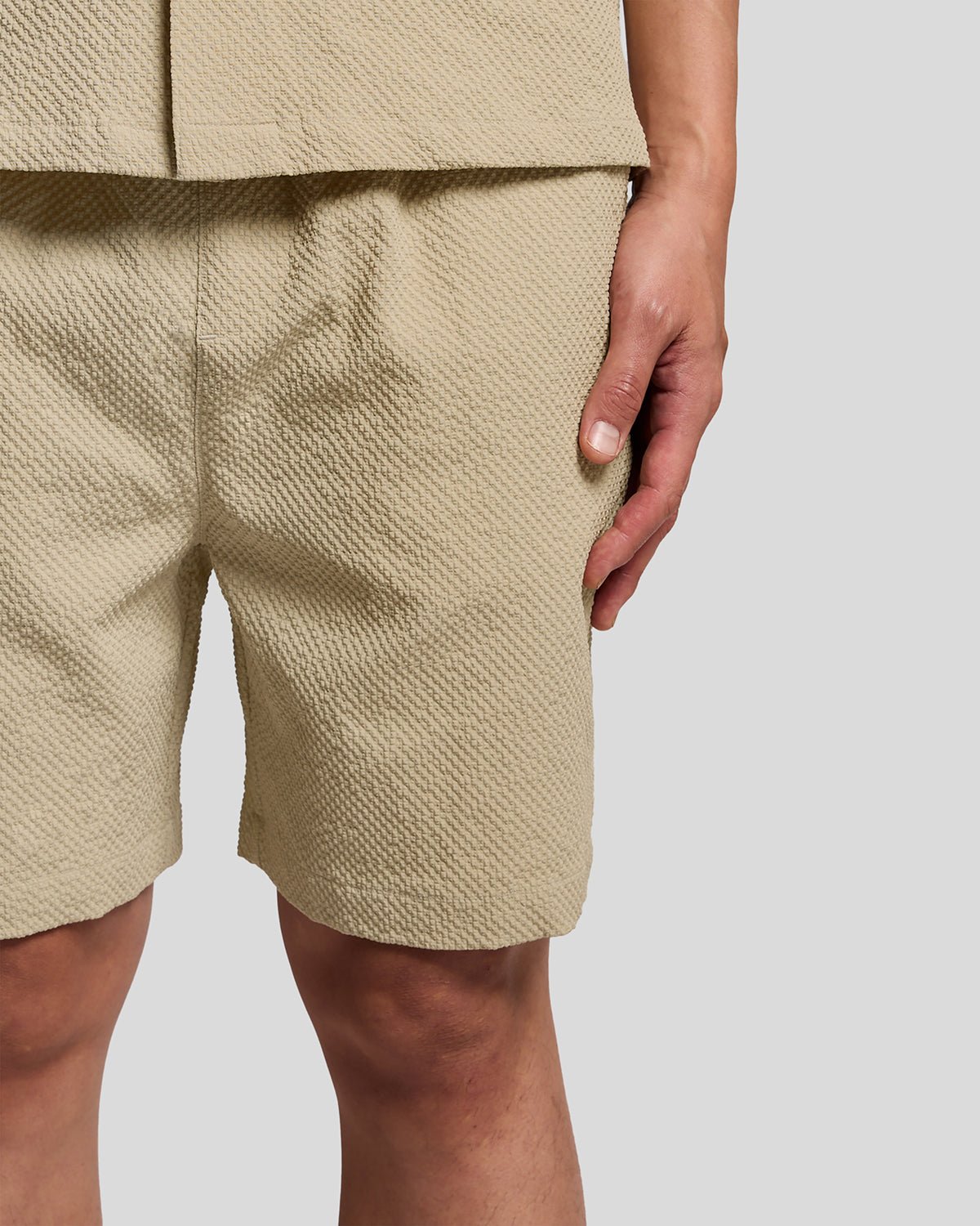 Un homme porte un short de plage texturé couleur Savona Clay