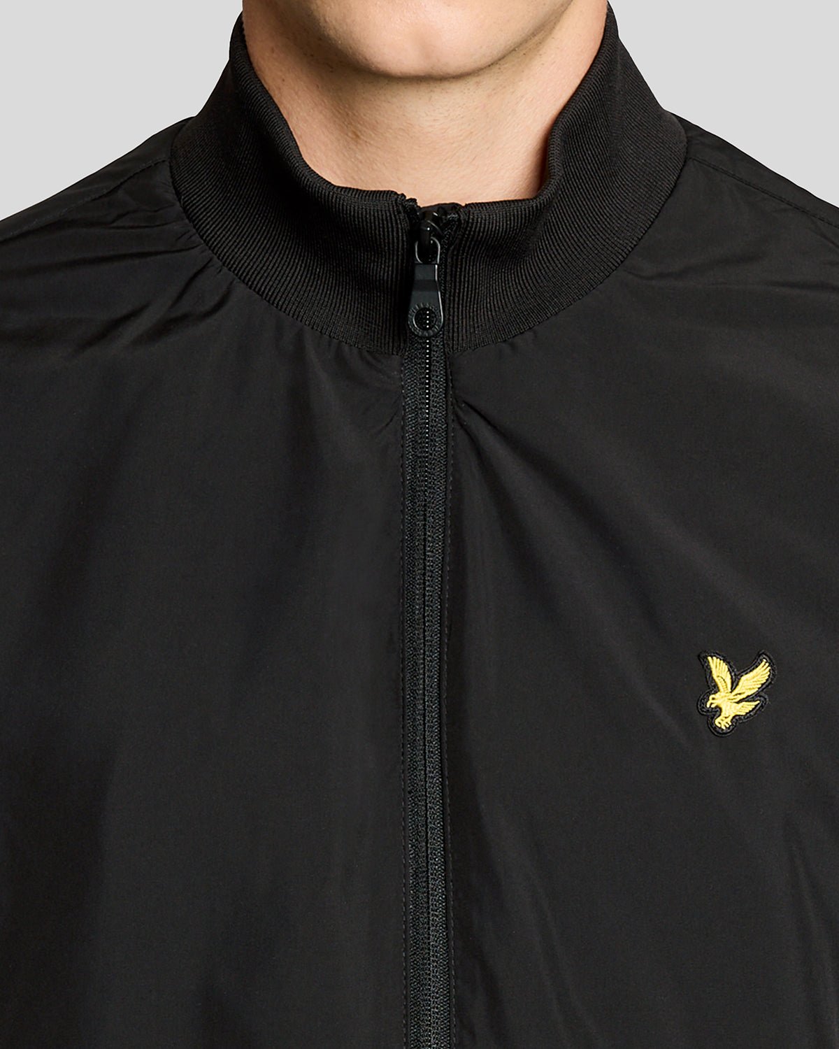 Un homme porte une veste à col cheminée de couleur noir jais
