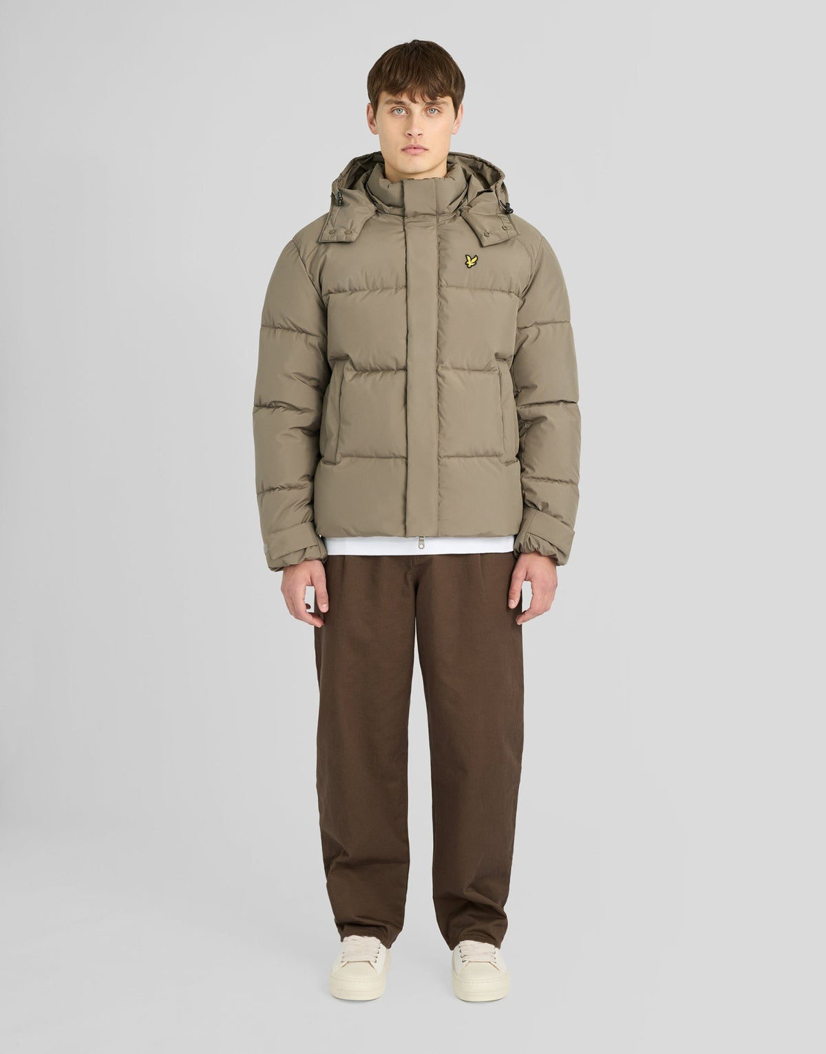 Mann trägt eine Kapuzen-Daunenjacke in der Farbe „Khaki Ash“
