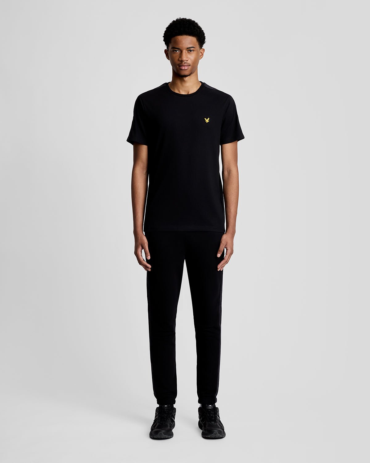Hombre lleva camiseta deportiva con cinta jacquard en color negro azabache.