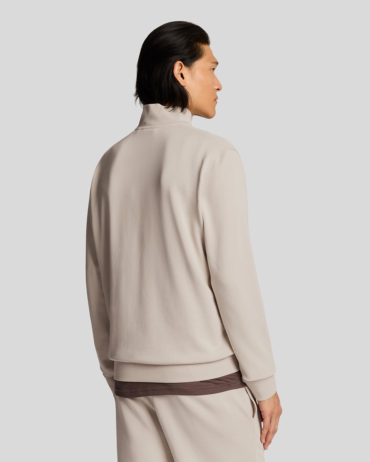 Un homme porte un sweat-shirt à fermeture éclair 1/4 en coton ultra-fin, couleur Cove