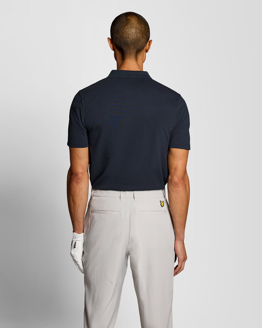 Un homme porte un polo technique bleu marine foncé
