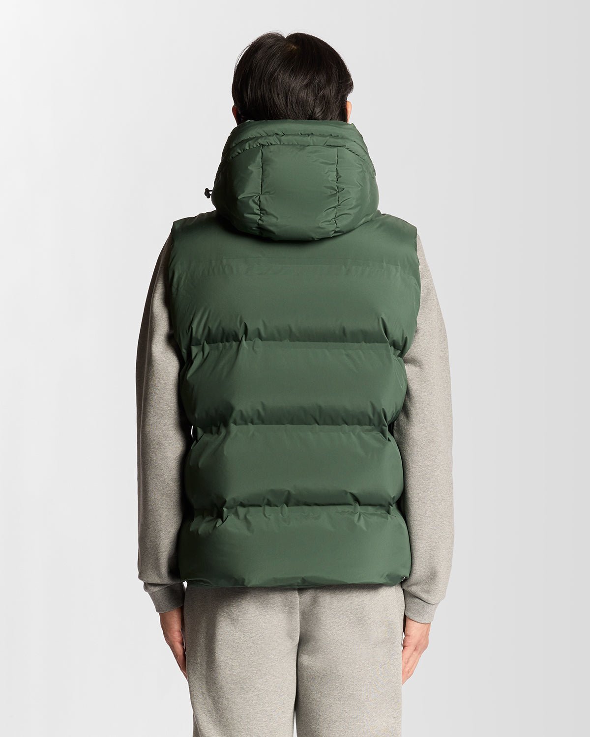 Homme portant un gilet matelassé à capuche épais, couleur Dark Pine