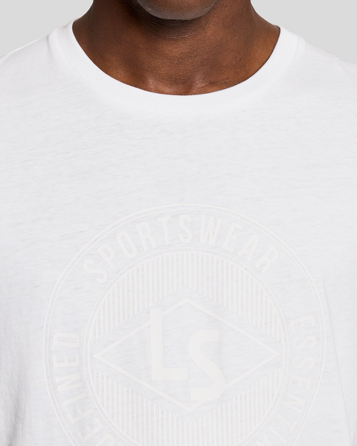 Homme portant un t-shirt blanc avec le logo graphique « Sports Redefined »