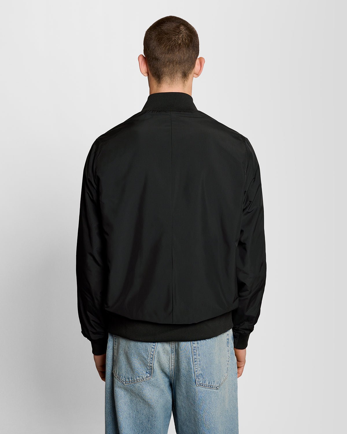Un homme porte une veste à col cheminée de couleur noir jais
