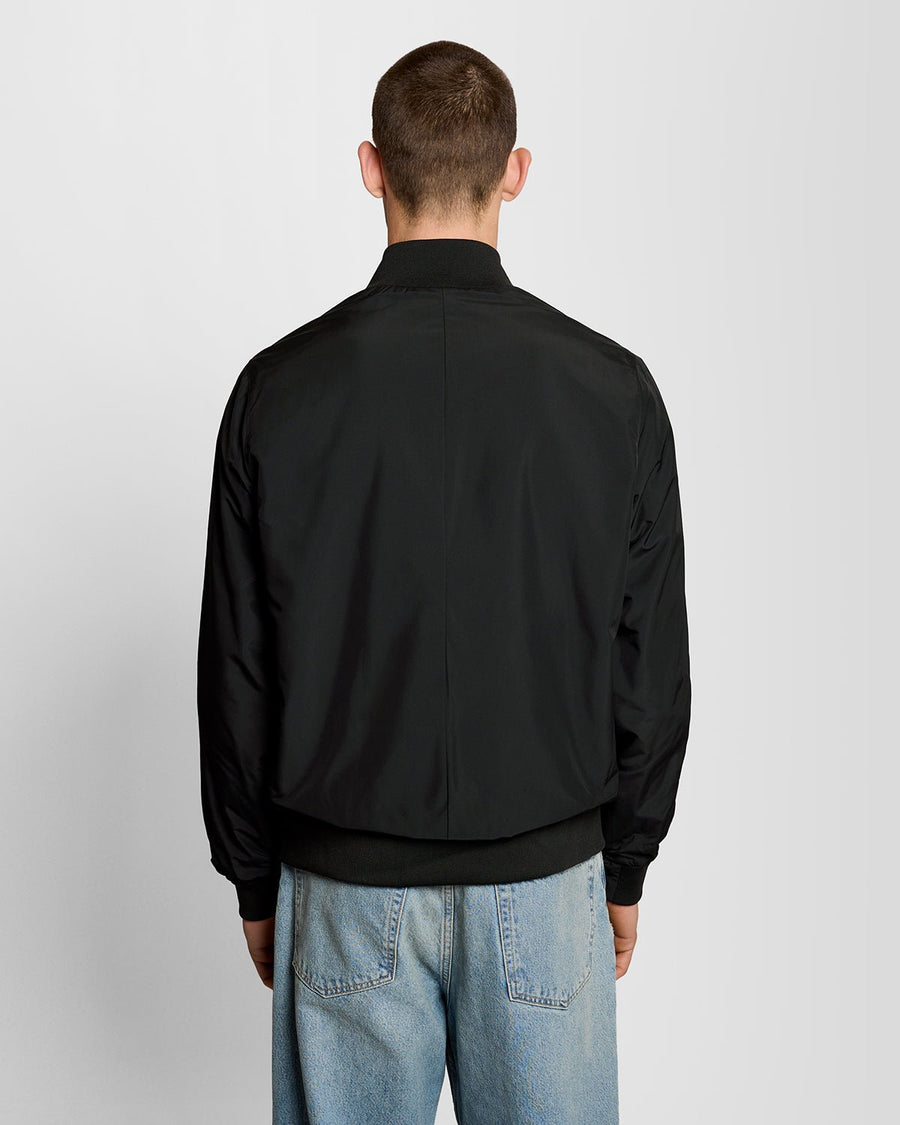 Un homme porte une veste à col cheminée de couleur noir jais