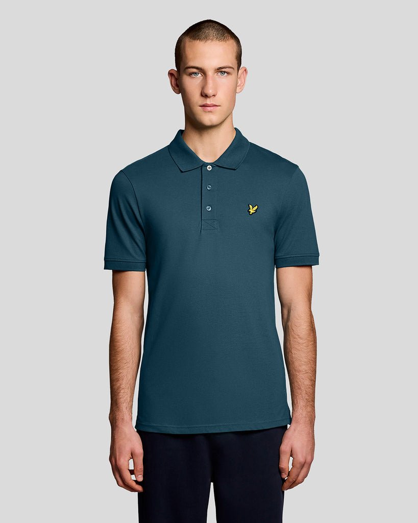 Un homme porte un polo « Everyday Cotton » de couleur bleu sarcelle intense