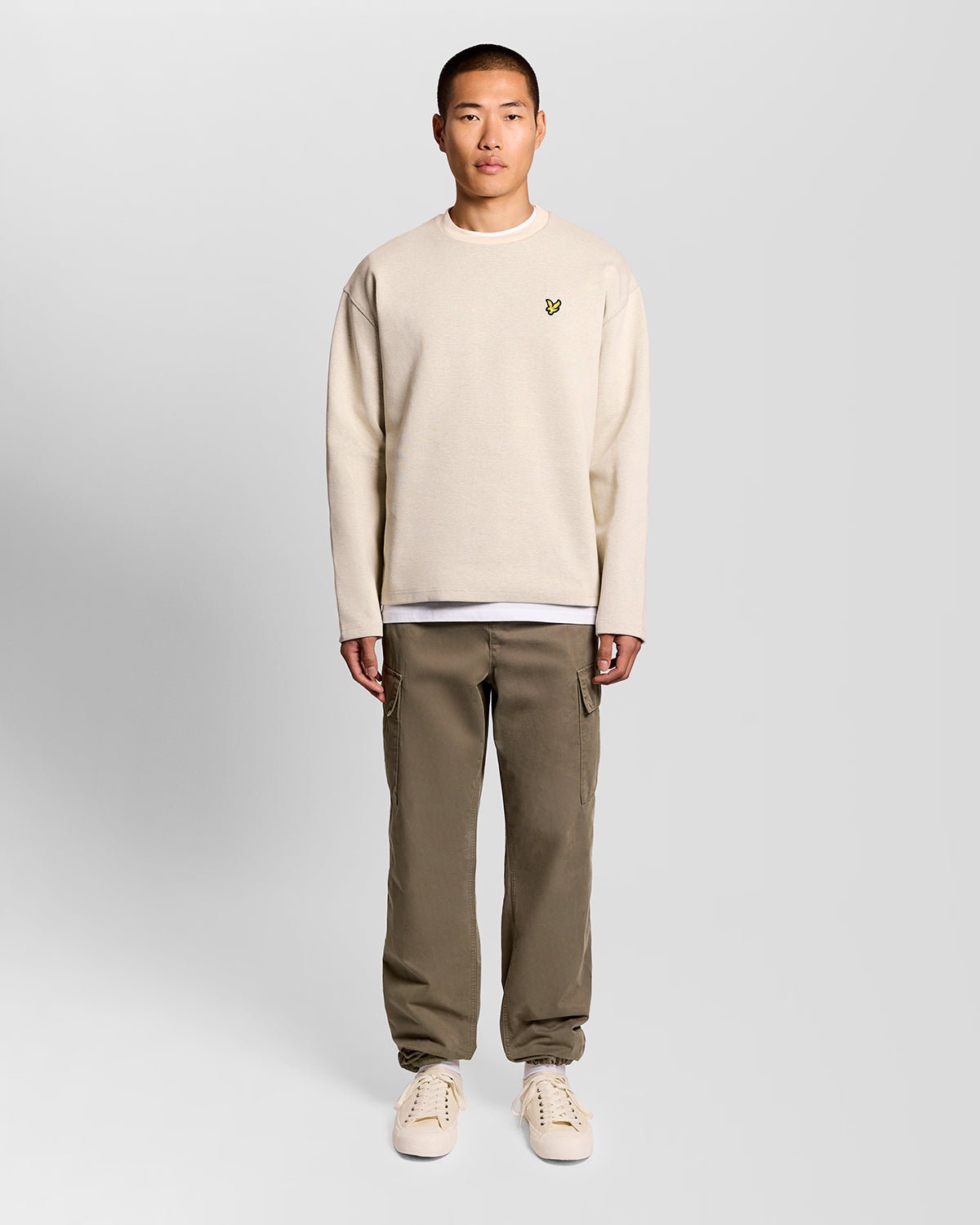 Un homme porte un pantalon cargo à revers de couleur kaki cendré