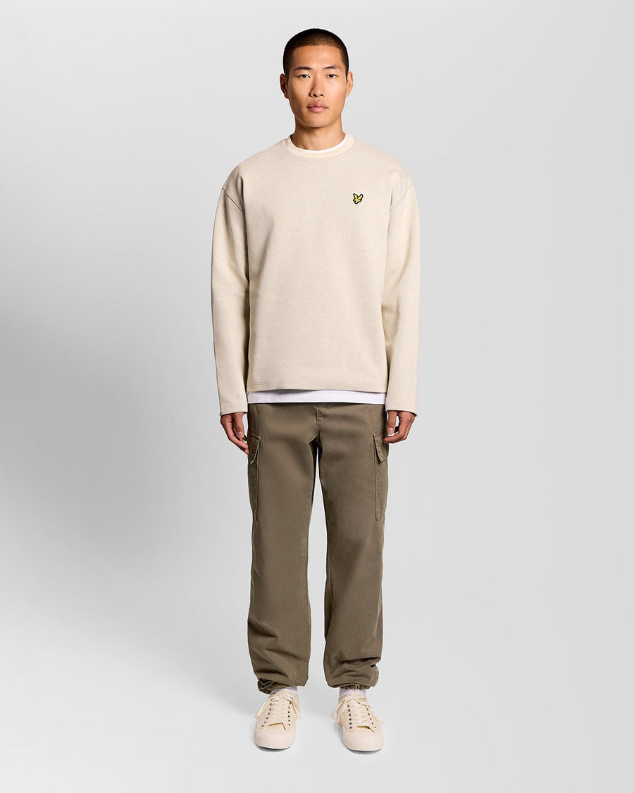 Un homme porte un pantalon cargo à revers de couleur kaki cendré