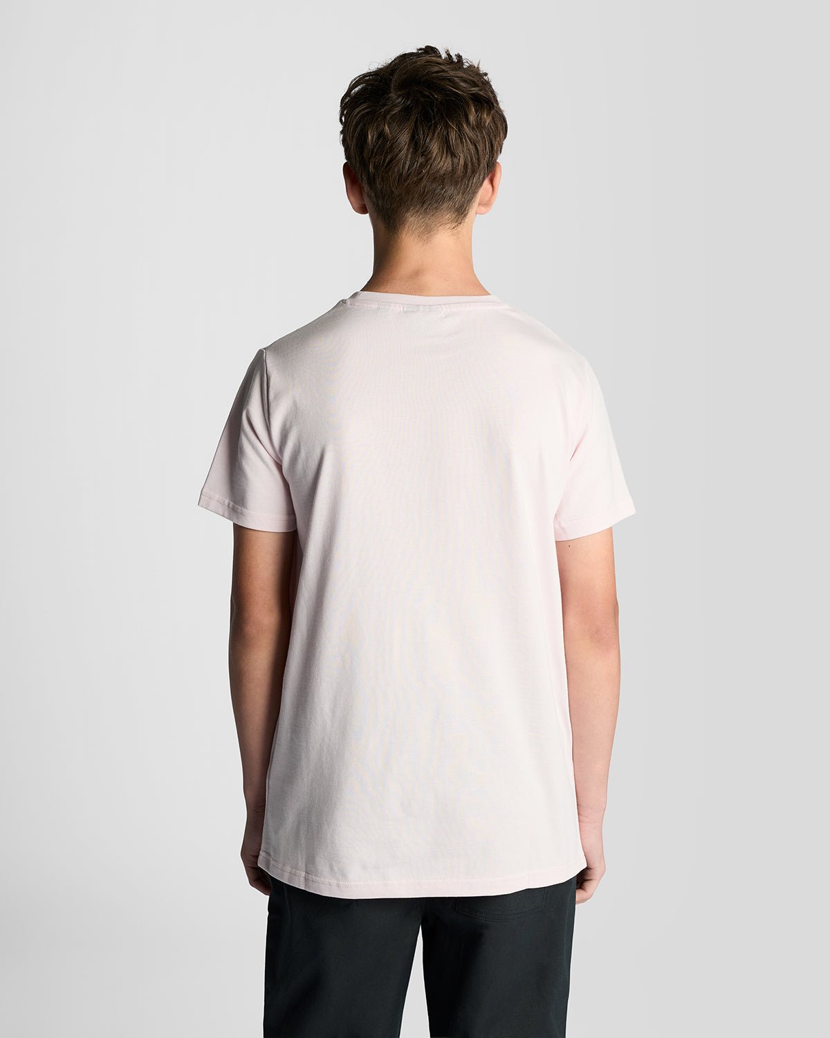 Un homme porte un t-shirt à col rond en coton rose pâle