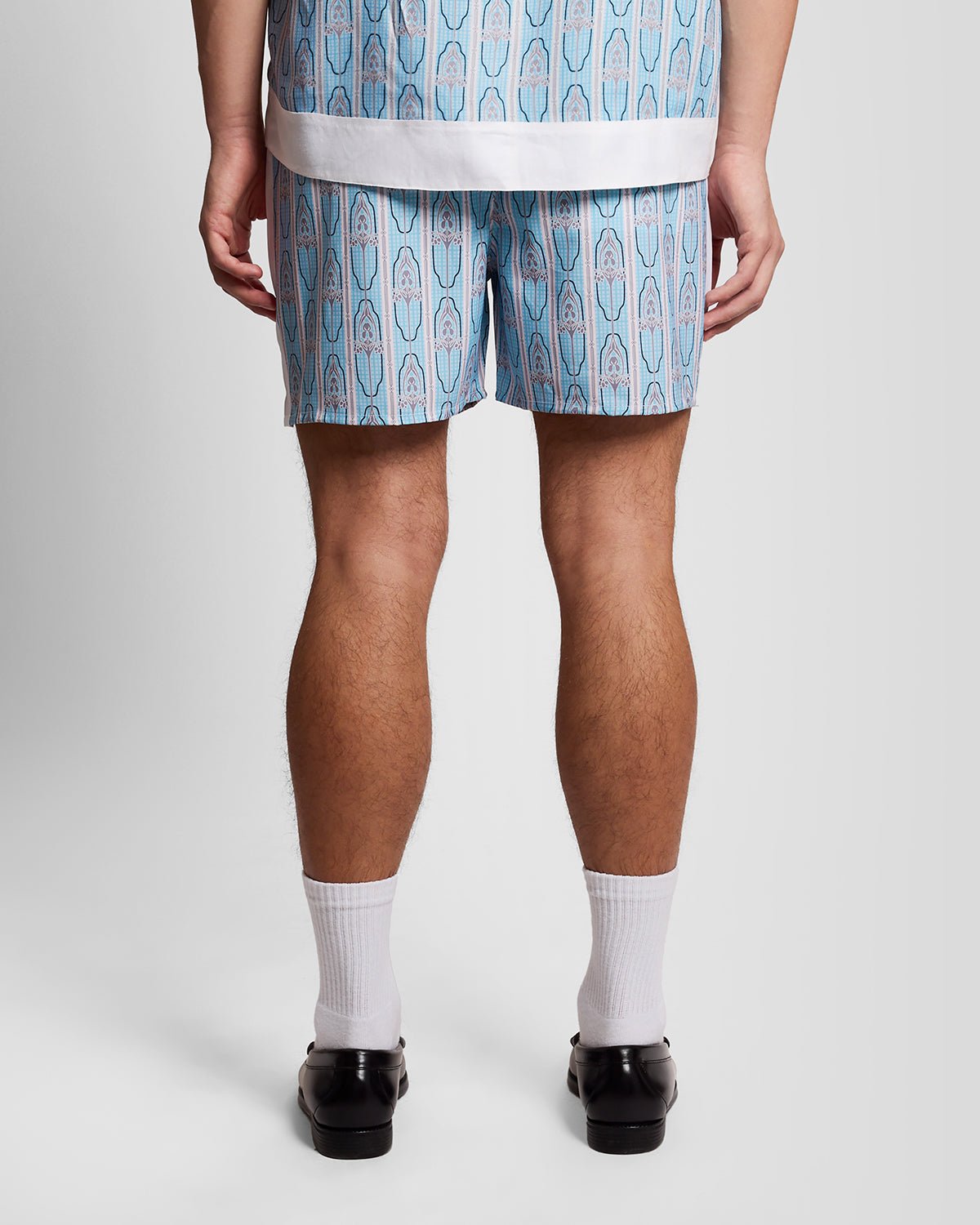 Homme portant un short de bain à motifs floraux, couleur crème amande/bleu de Parme