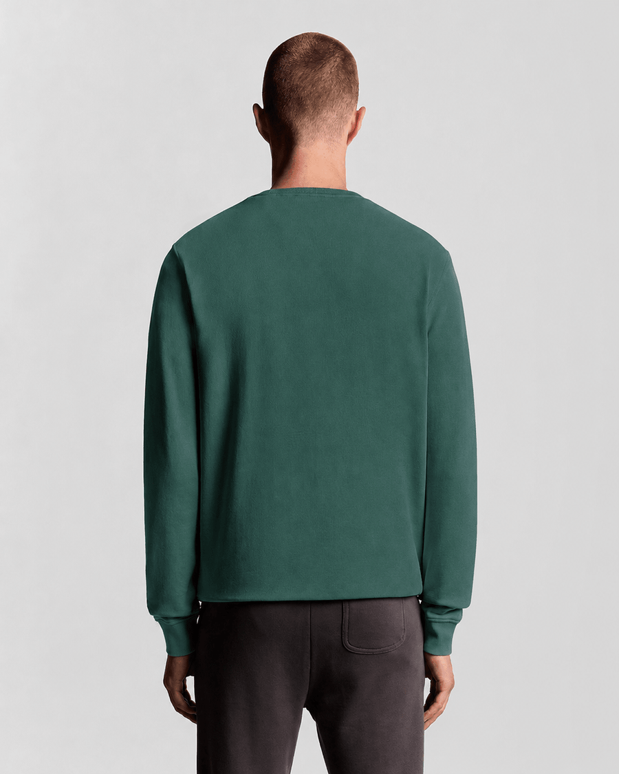 Un homme porte un sweat-shirt à col rond en coton, couleur Everglade