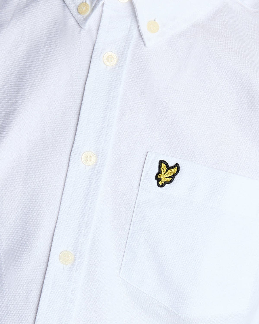Un homme porte une chemise Oxford en coton à boutons, de couleur blanche