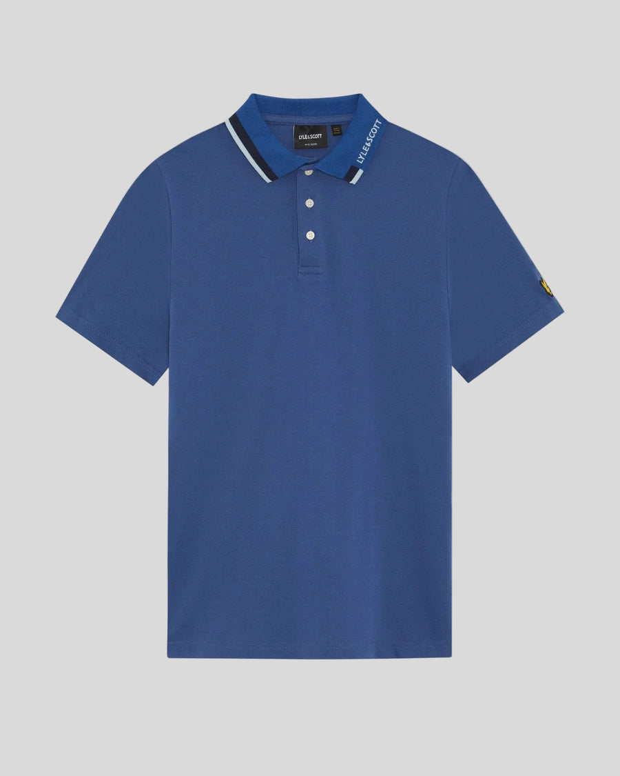 Un homme porte un polo à logo bicolore bleu barbeau foncé