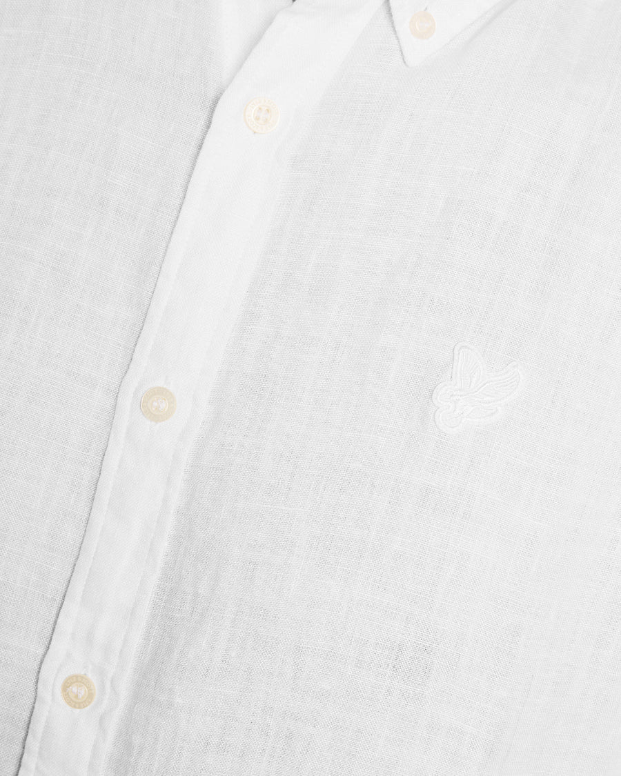 Un homme porte une chemise en lin à manches courtes blanche