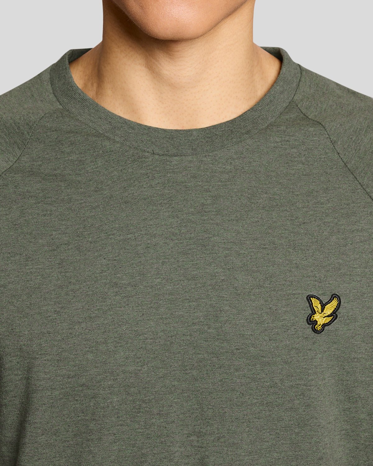 Un homme porte un t-shirt Marl Raglan de couleur kaki Tri Marl